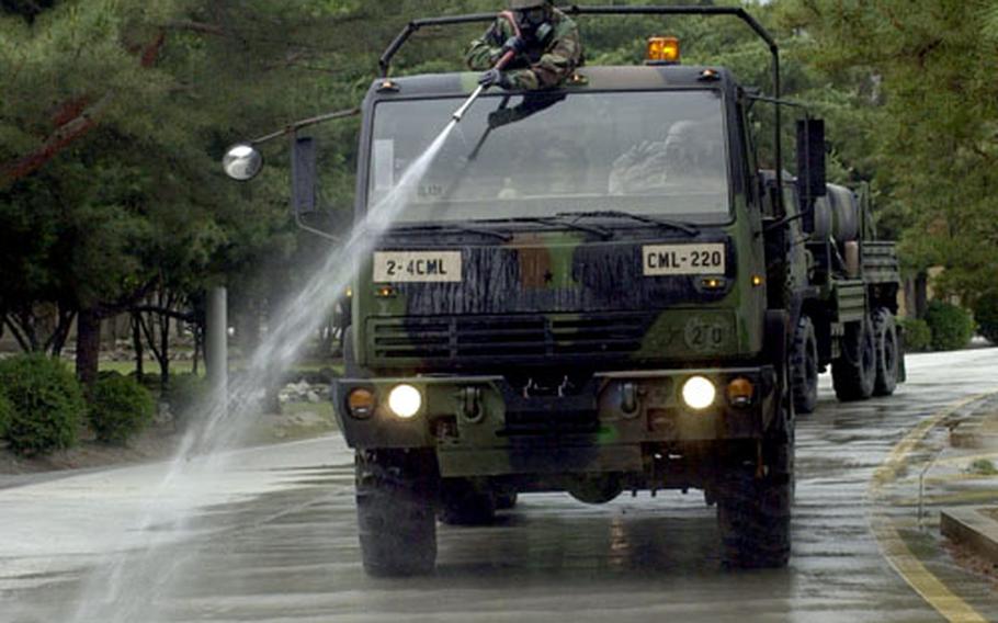 Soldiers hose down the road during the mock chemical attack and response exercise.
