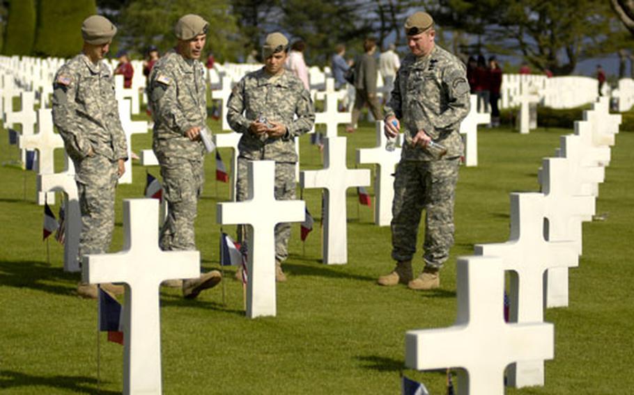 Chaplain (Maj.) Jeff Struecker, second from left, talks about a fallen Ranger with fellow members of the 1st Battalion, 75th Ranger Regiment, Staff Sgt. Corey Remsburg, Sgt. Nick Scarafile and Sgt. 1st Class Rob Sciandra at the Normandy American Cemetery Friday near Colleville-sur-Mer, France. Both the 1st and 5th Ranger Battalions fought at D-Day.