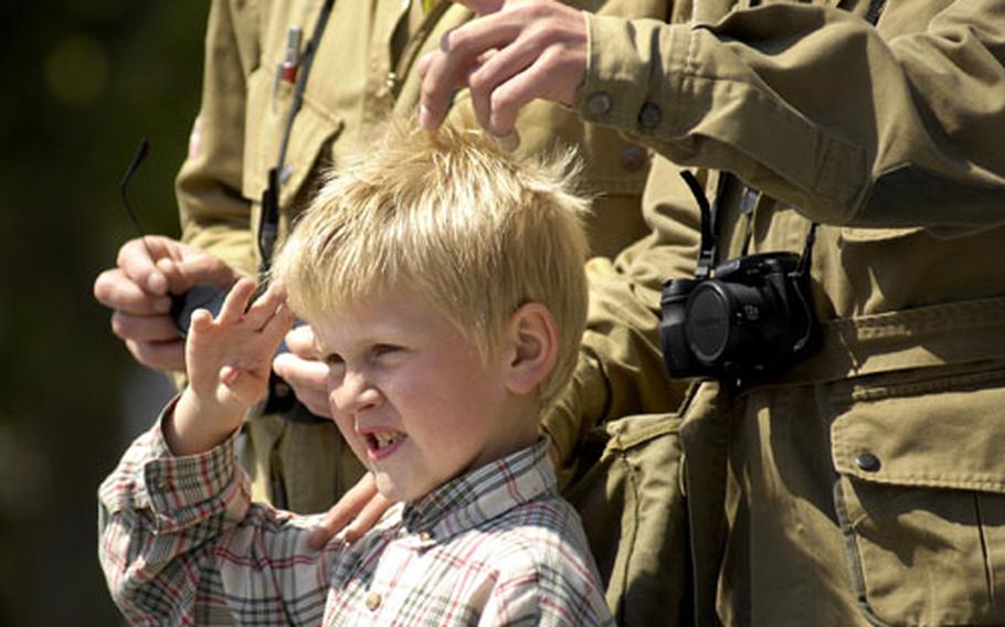 A boy poses with some reenactors in town for the 65th anniversary of D-Day in the town of Sainte Mere Eglise, France.