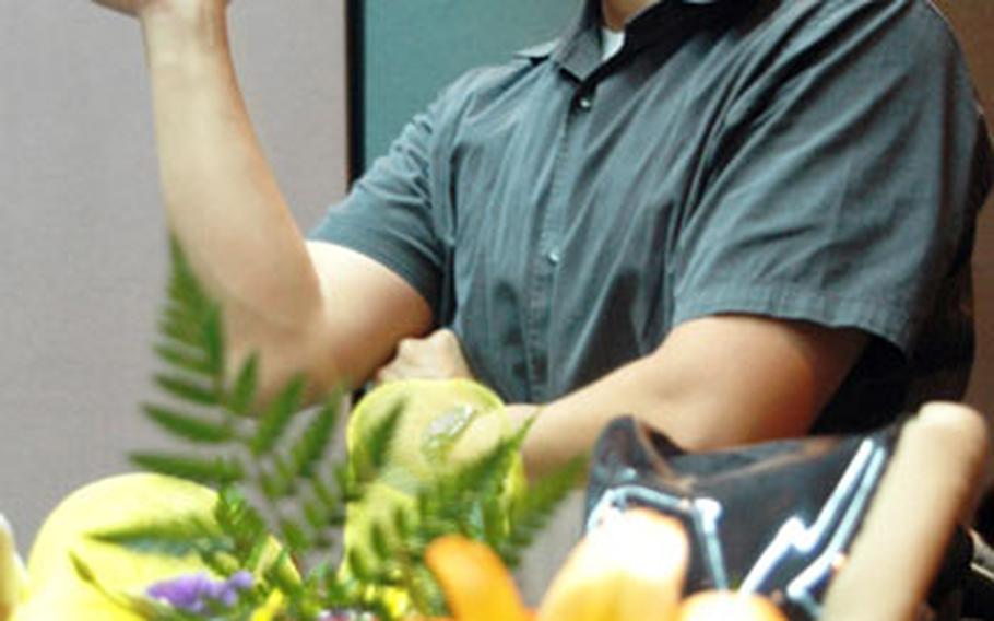 Joe Komenkul videos Friday&#39;s graduation ceremony and waits for his wife, Suerjee Lee, to walk across the stage.
