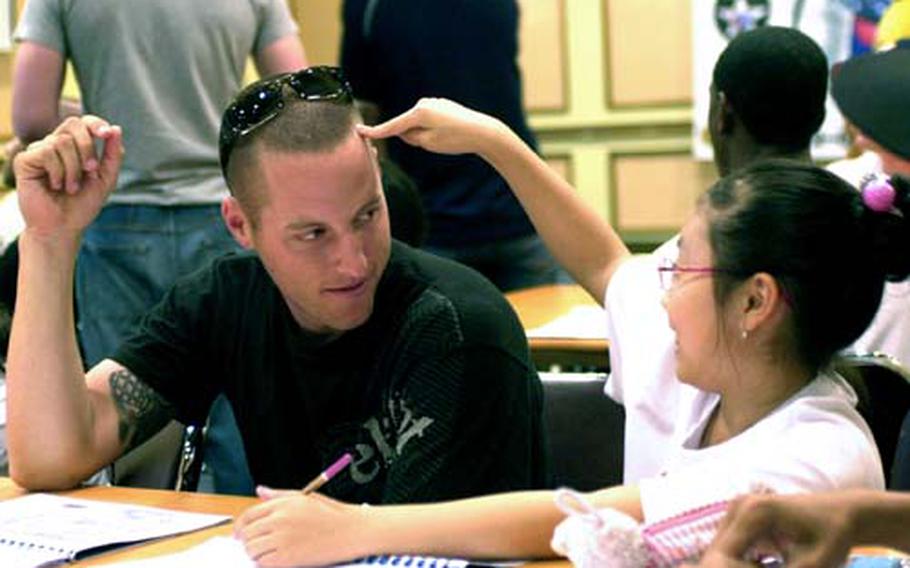 Park Hye-bin, right, shares a moment with Pvt. 2nd Class Matt Theilicker during the 2nd Infantry Division’s “Good Neighbor English Camp” on Thursday at Camp Casey, South Korea.