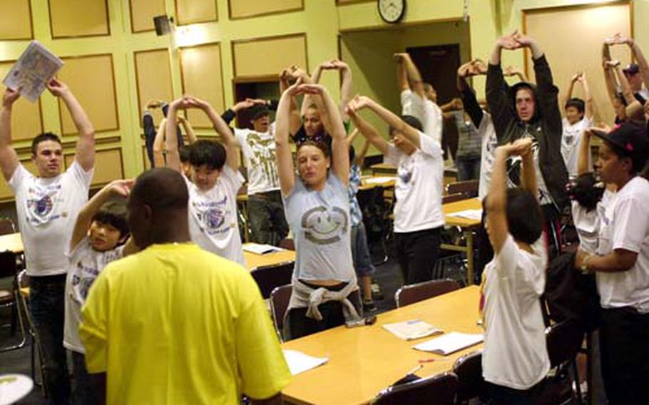 Soldiers and students participate in a stretching exercise.