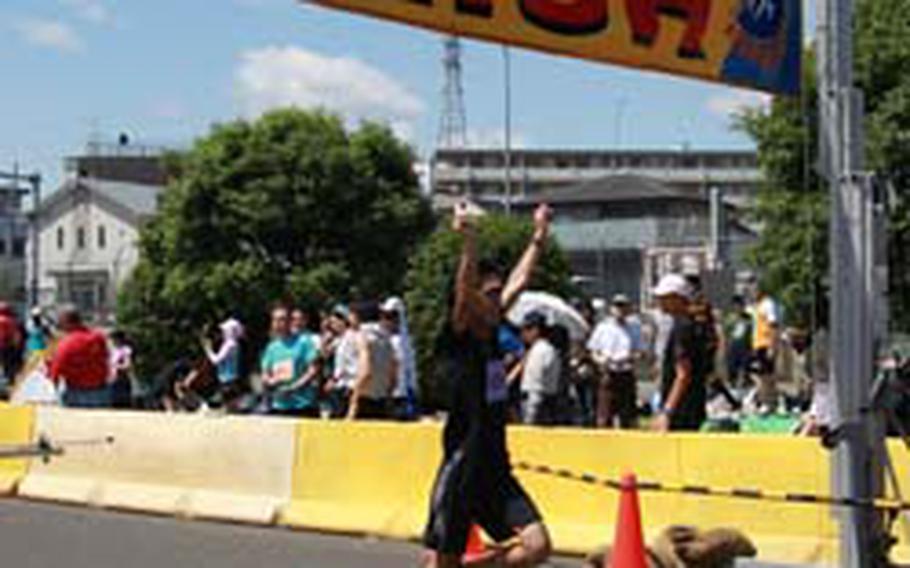 A participant from the Japanese community rejoices during his finish of the five kilometer foot race.