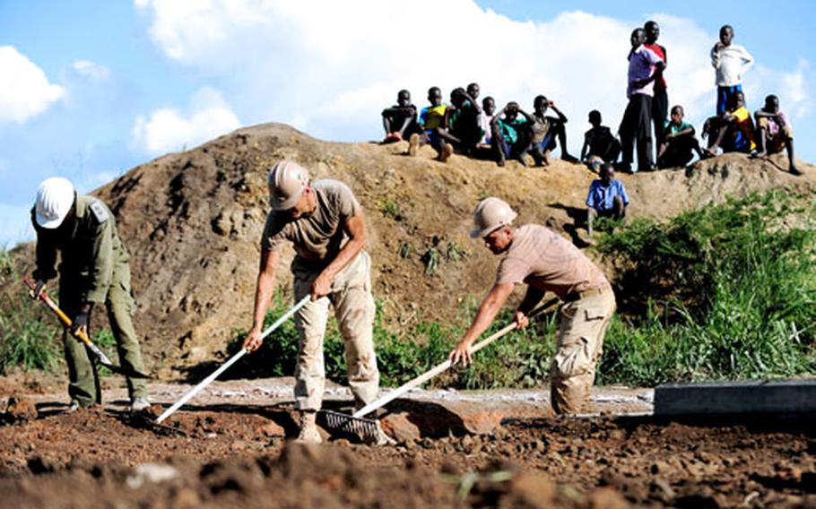 Residents of Aroma, Uganda, look on as Seabees from the U.S. Naval Mobile Construction Battalion-11, Combined Joint Task Force-Horn of Africa, grade the area surrounding a bridge under construction. The Navy has changed its advancement system to ensure all sailors have an equal shot at promotion, and are not disadvantaged by tours of duty downrange.
