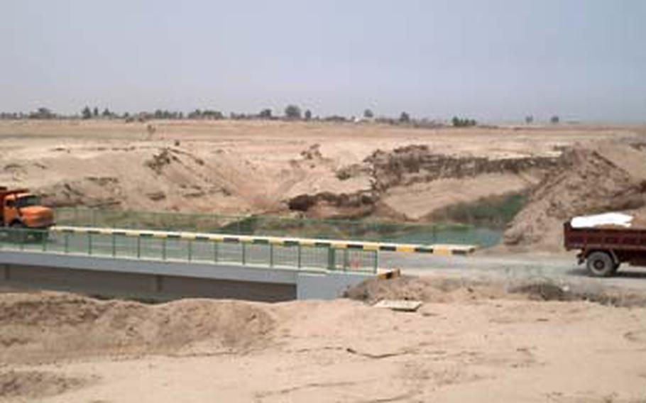 Trucks cross over the newly reopened Mujarrah Canal Bridge, near Fallujah.