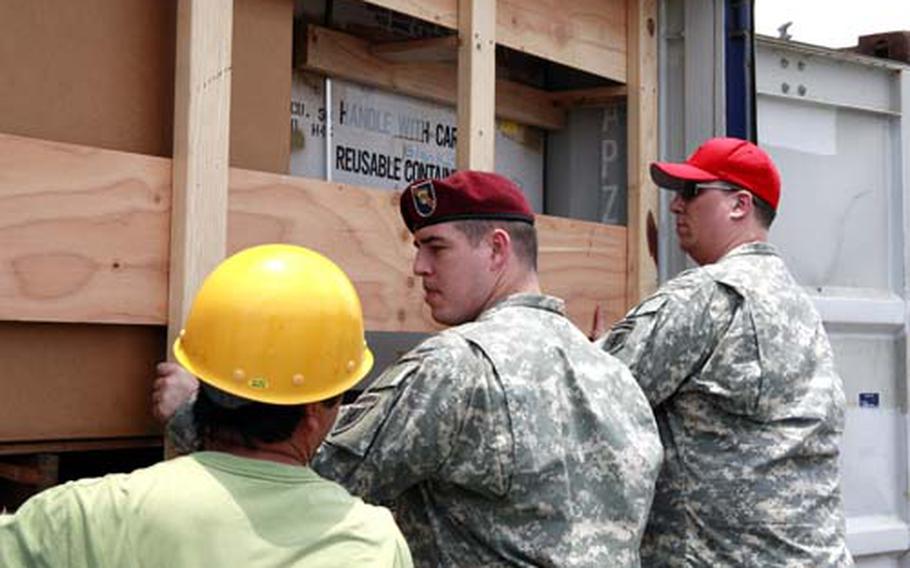 (From left) Kaoru Teruya, from U.S. Army Garrison, Torii Station on Okinawa, along with Spc. Lucas Callaghan and Sgt. Jesse Burk, both from the 87th Quartermaster Detachment, fix wooden braces on one of 26 containers destined for Sri Lanka.