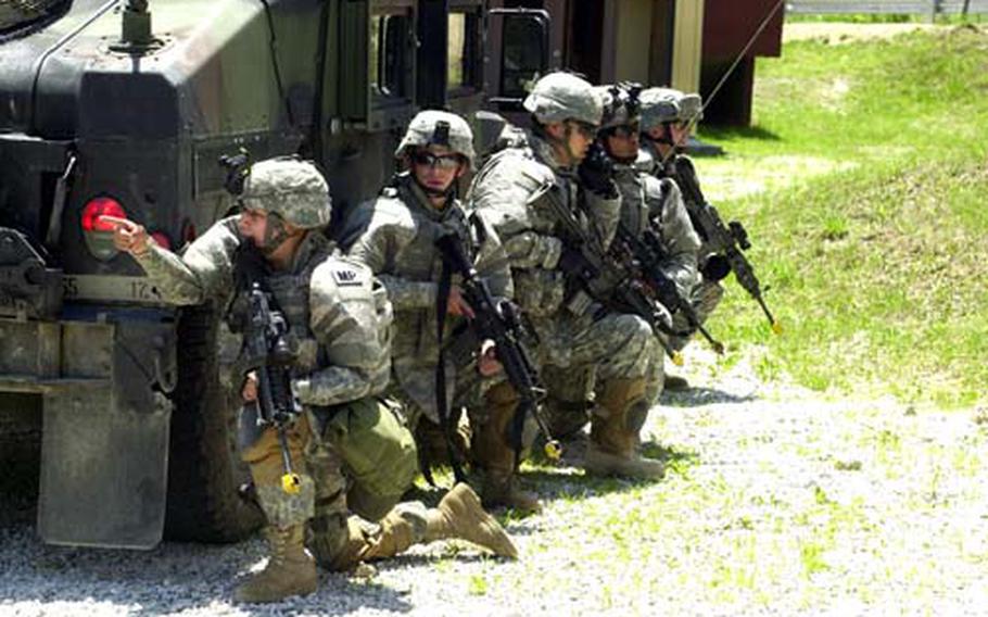 Military police react to sniper fire as they prepare to evacuate civilians from an apartment building during a training exercise Thursday at Rodriguez Range in South Korea.