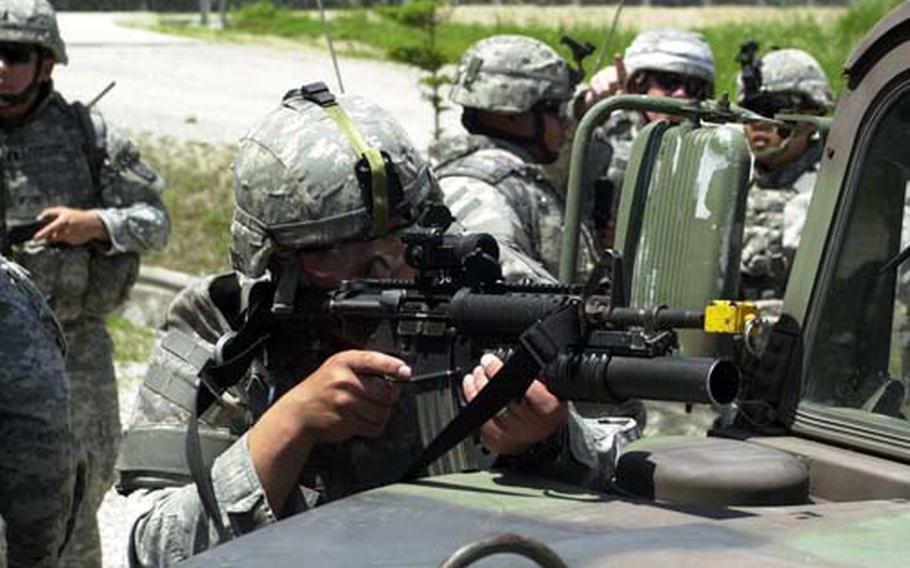 MPs guide civilians out of an apartment building under sniper fire during a training exercise.