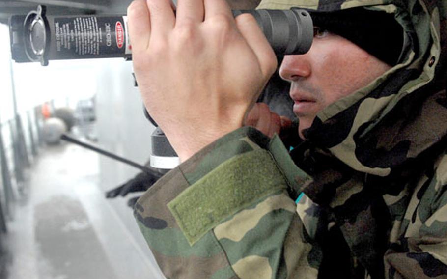 Petty Officer 3rd Class James Schnabel sights in on a target with the Green Beam Dazzler III-C at Cheatham Annex, Va. This summer the Navy will use laser lights on ships and for deployed sailors downrange.