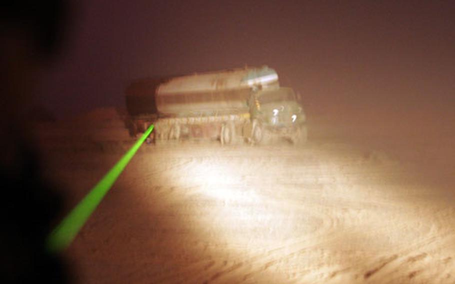 A truck moving on ASR Long Island in Iraq is scanned with a laser light in June 2007 by Marine Pfc. Collin F. Crouch, Military Police Company, 2nd Maintenance Battalion.