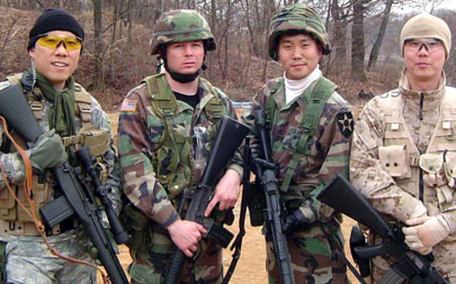 Spc. Clayton Baker, second from left, poses with South Koreans dressed in U.S. military uniforms after playing a survival game in which players pretend to be fighting a war.