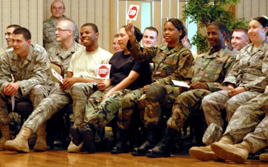An airman holds up a “STOP” sign during the presentation of “Sex Signals.”