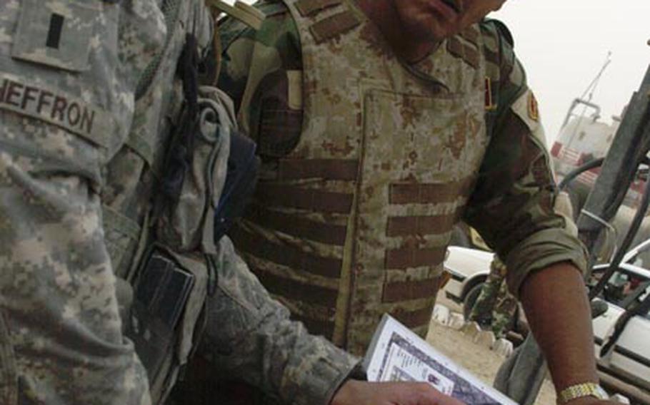 Before a mission, 1st Lt. Bart Heffron talks with the senior enlisted Iraqi soldier in the patrol team.