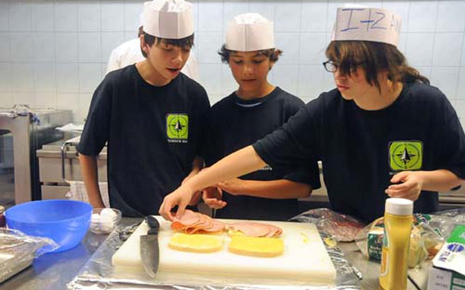 Andrew Winkler, left, Dominik Hinkleman, both from Baumholder, and Marissa Juarez from Heidelberg, prepare a Monte Christo sandwich in a culinary arts class at this year&#39;s Camp A.R.M.Y. Challenge in Bitburg, Germany.
