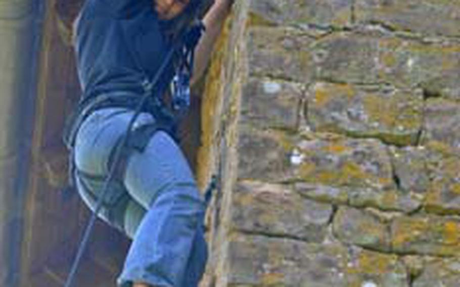 Kaitlyn Martin from Vicenza , Italy, looks for a foothold before making her way to the top of the building during a rock climbing session.