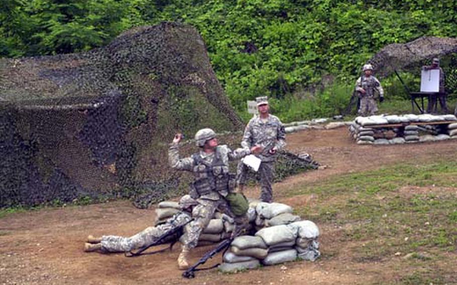 Pvt. Remington Herrera throws a grenade at a target area as part of his effort to earn an Expert Infantry Badge this week at Camp Casey.