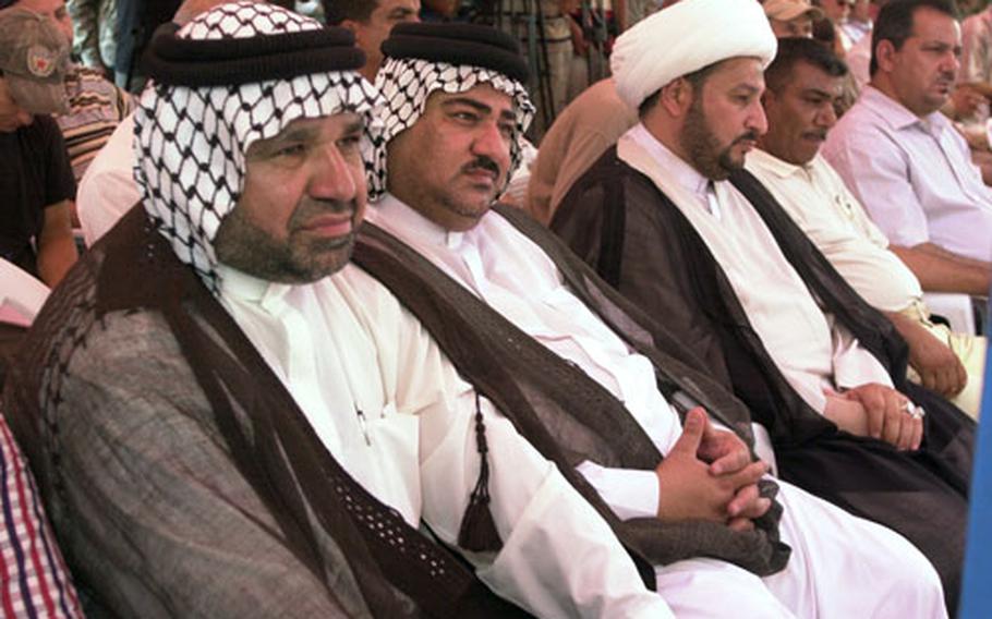 A small crowd of U.S. Army officials, Iraqi government representatives and sheiks from Sadr City listen as Gen. Abud Kambar al-Malliki, the top Iraqi army commander in Baghdad, warned terrorists to “stay in your homes” or face a fight from Iraqi forces as U.S. troops pull back from Iraq’s cities at the end of June. The warning came minutes before the U.S. Army signed papers leaving Joint Security Station Sadr City to the 44th Iraqi Army Brigade, part of the 11th Iraqi Army Division. The transfer is one of dozens the Americans have made in recent weeks to comply with a June 30 deadline to move combat troops out of cities.