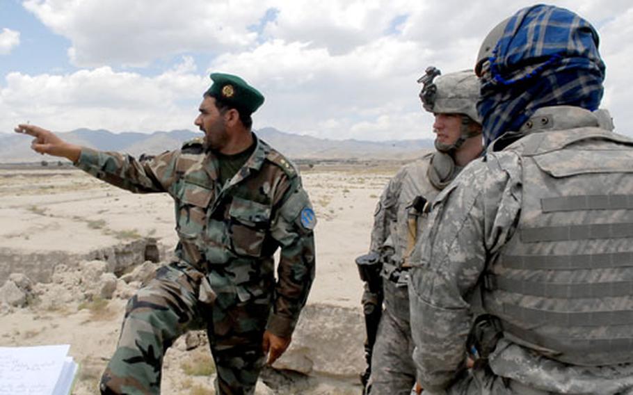 Afghan National Army Lt. Col. Fazul Rahaman describes to Capt. Bobby Davis, 33, of Columbus, Ga., events in the wake of an ambush on a U.S. and Afghan army convoy in the village of Samawat on Saturday. Davis&#39; 2nd Platoon, Dog Company of the 4th Brigade, 25th Infantry Regiment out of Alaska, arrived on the scene during the firefight to help the ambushed forces.