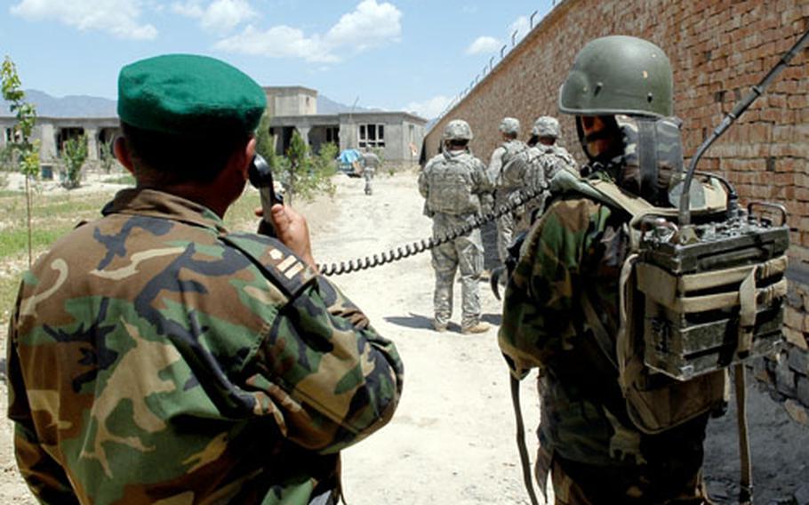 Afghan Army Lt. Col. Fazul Rahaman makes contact with his troops by radio as U.S. and Afghan forces search the walled compound of a home, called a kalat, following an ambush on a U.S. convoy in the village of Samawat on Saturday.