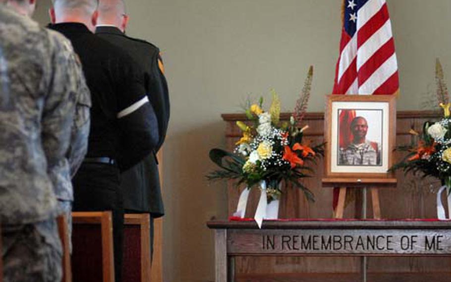 Soldiers pause as taps is played during a memorial ceremony for Capt. Kafele Sims Tuesday in a chapel on Tompkins Barracks. Sims, 32, died June 16th in Mosul, Iraq, in a non-combat related incident while serving as a physician&#39;s assistant with the 18th Engineer Brigade.