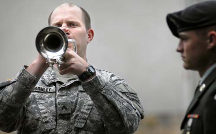 Sgt. Samuel Ghormley plays taps as Pvt. 1st Class Chad Finholt looks on.
