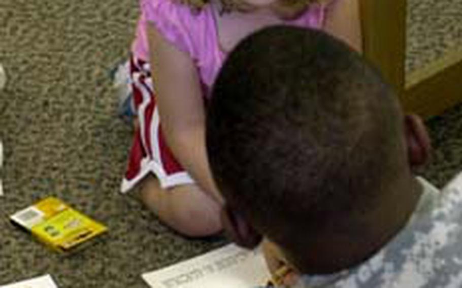 Maggie Stalter, 4, talks with Maj. Gen. John W. Morgan III, commander of the 2nd Infantry Division, Wednesday at the Camp Red Cloud Library in South Korea. She is reacting to news that Morgan was about to give her a gift, a 2ID, Indianhead-shaped coin.