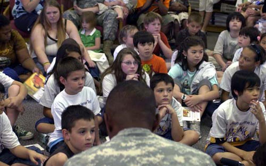 Maj. Gen. John W. Morgan III, commander of the 2nd Infantry Division, reads "While You Are Away" to children at the Camp Red Cloud Library in South Korea Wednesday.