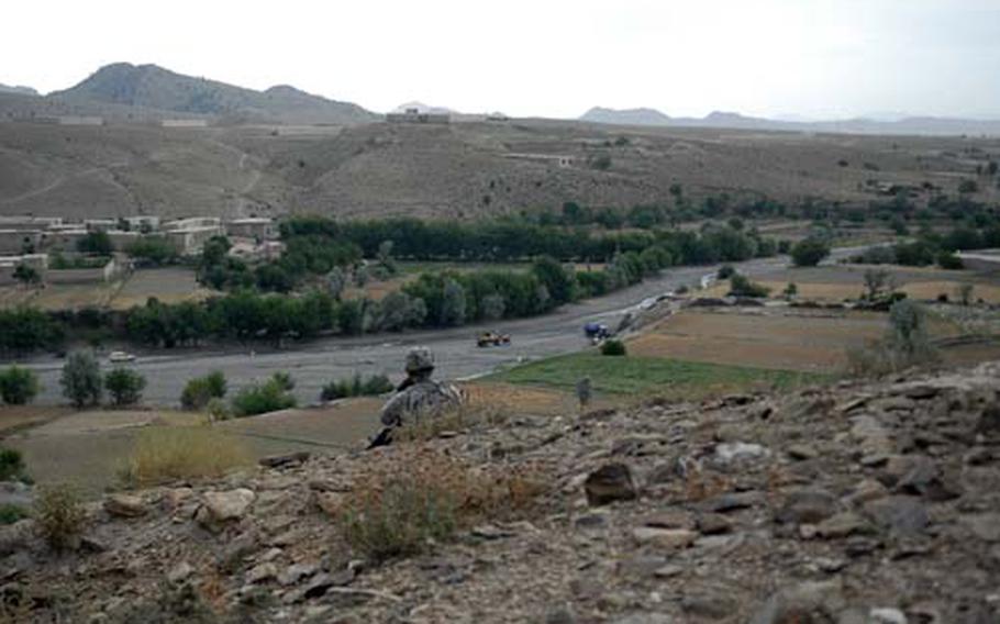 An American soldier stands guard on a hilltop overlooking a wadi in the village of Shembowat, Afghanistan. The village is often the point of origin for mortar and rocket attacks from insurgent fighters who threaten anyone who cooperates with the government or U.S. and coalition forces.