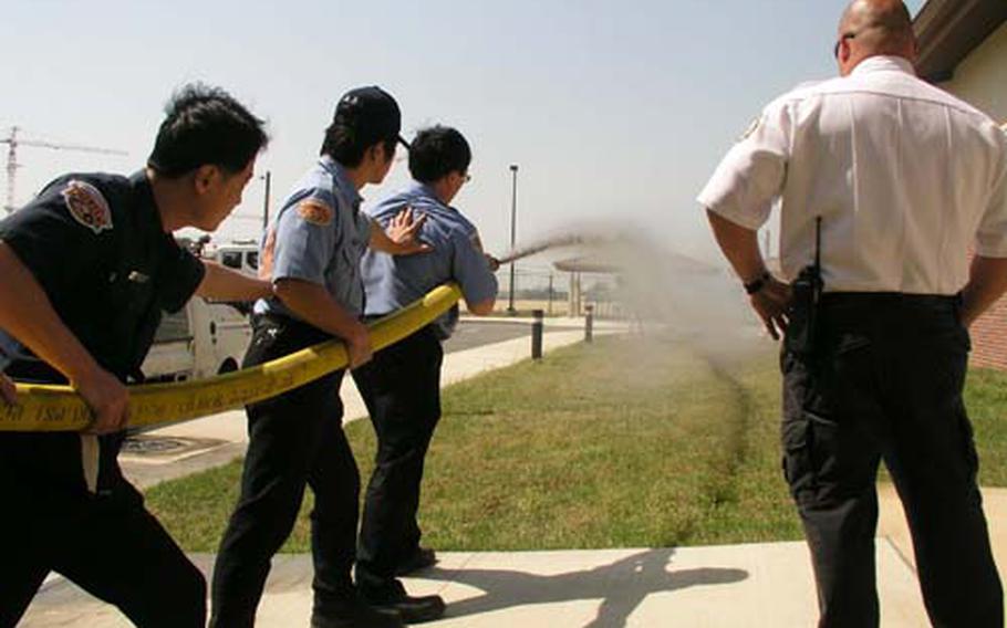 At Camp Humphreys in Pyeongtaek, South Korea, last month, firefighters brace themselves while testing the internal hydrant system of a recently built barracks in the post’s MP Hill section. The garrison is currently taking part in an Armywide campaign to foster fire prevention practices among troops, families and others.