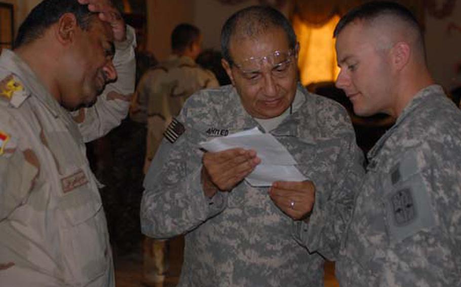 Capt. Nicholas Sinclair, right, commander of Company C, 2nd Battalion, 28th Infantry Regiment, communicates with his Iraqi counterpart with the help of an interpreter Monday.