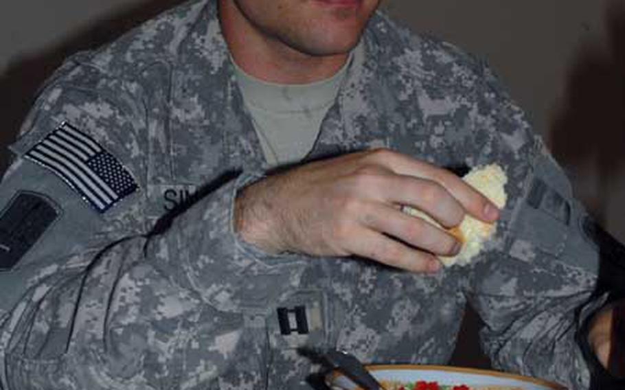 Capt. Nicholas Sinclair, 28, of Eastpointe, Mich., enjoys a traditional meal with his Iraqi counterpart.