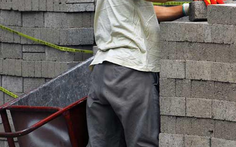A construction worker moves cinder blocks Thursday morning outside one of three high-rises at Hannam Village that are under renovation. The project is expected to be completed by early summer 2010 and add 264 housing units, easing a shortage of U.S. military housing in Seoul.