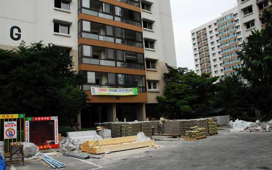 A construction worker moves building material outside one of three high-rises at Hannam Village that are under renovation. The project is expected to be completed by early summer 2010 and add 264 housing units, easing a shortage of U.S. military housing in Seoul.