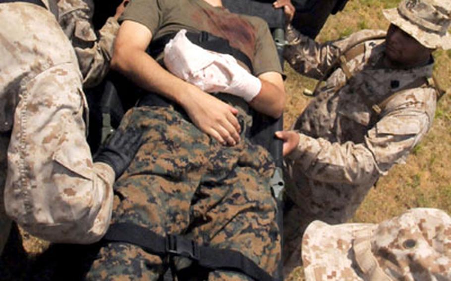 As soon as stretchers were unloaded from an ambulance, sailors carefully searched the wounded, checking for unexploded ordnance or booby traps before taking them into the forward resuscitative suite at Landing Zone Whippoorwill.