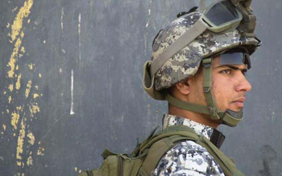 A National Police officer conducts an early-morning patrol in Hussainiyah. On Tuesday, the American troops that stay in the cities stay at the express invitation of the Iraqi military, U.S. commanders say. They will take the lead in mentoring and teaching Iraqis and take a back seat on patrolling and missions.