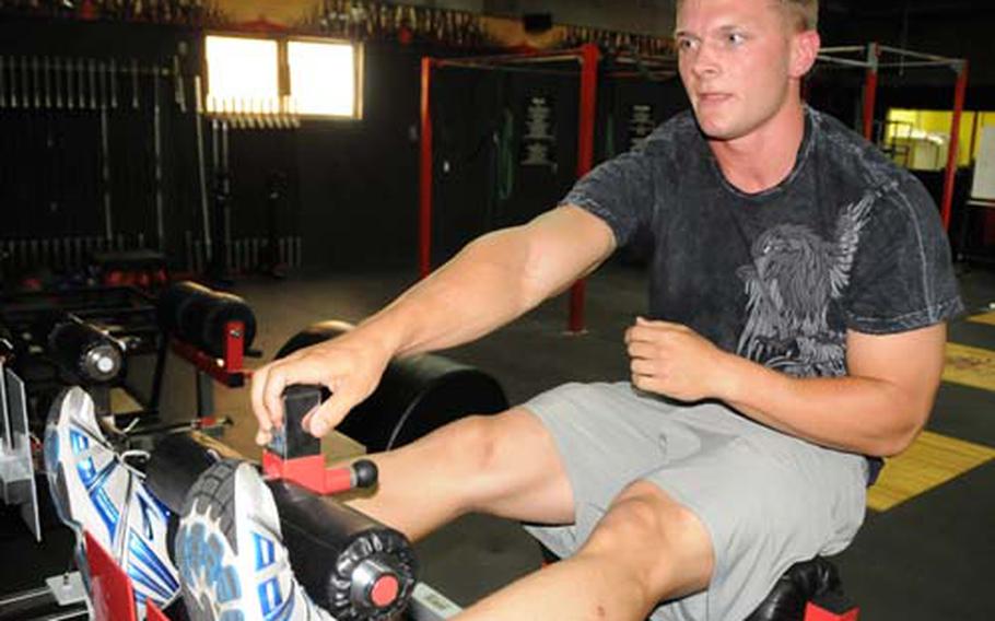First Lt. Rob Gerdes stretches out at the gym CrossFit Asia in Okinawa City on Tuesday before getting started on his CrossFit workout.