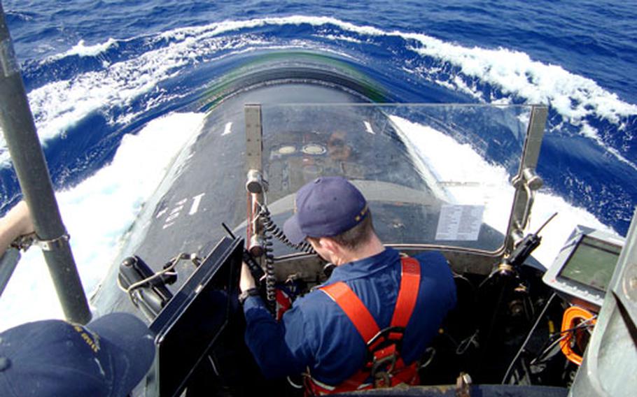 Lt. j.g. Wes Stange talks with the control room while observing from the bridge of the USS Seawolf as the boat surfaces in the Pacific Ocean in February.