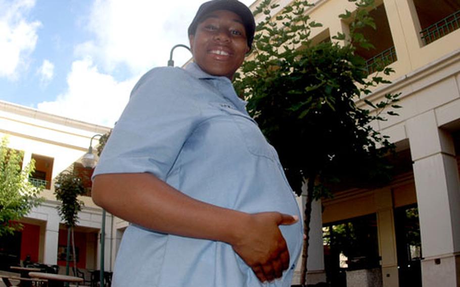 Petty Officer 2nd Class Dominique Jackson, 22, poses with her hands on her belly. Jackson was assigned to the USS Mount Whitney when she learned she was pregnant. Per Navy instruction, which states pregnant women cannot serve aboard ship after their 20th week, Jackson was re-assigned to Naples, Italy.