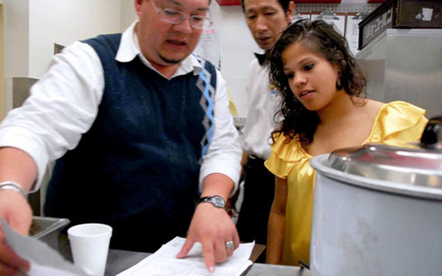 Carola Cintron-Arroyo gets some training from Luis Pena Jr., the catering manager of the Harbor View Club at Sasebo Naval Base in Japan. Cintron-Arroyo returned to Sasebo for the summer after her freshman year at Harvard University.
