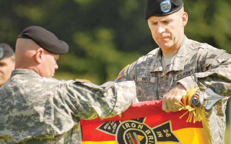 Col. Pat White, right, 2nd Brigade Combat Team commander, and the brigade’s Command Sgt. Maj. Michael Eyer case the flag of their unit during a reflagging ceremony Wednesday in Baumholder. During the ceremony, White relinquished command of the 2nd BCT, which is being replaced by the 170th Infantry Brigade.