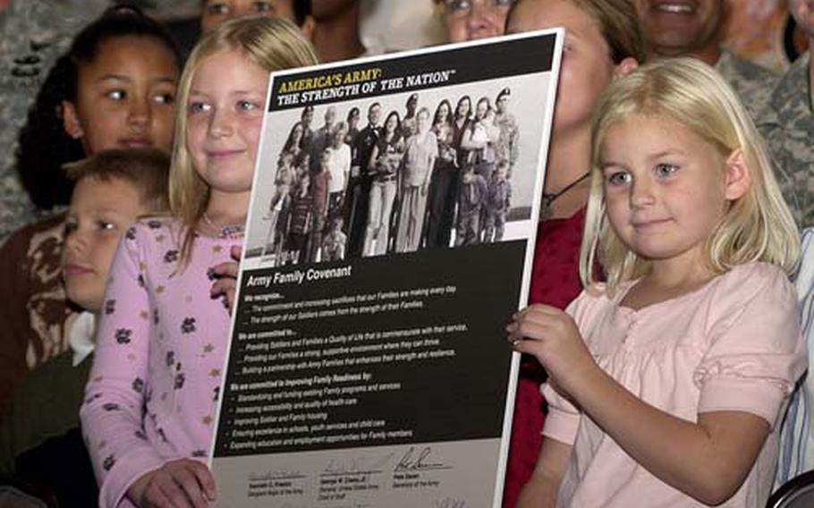 Alyssa DeMarco, left, 8, and her sister Cayla, 6, hold up the Army Family Covenant following its signing in Heidelberg, Germany, in October, 2007.
