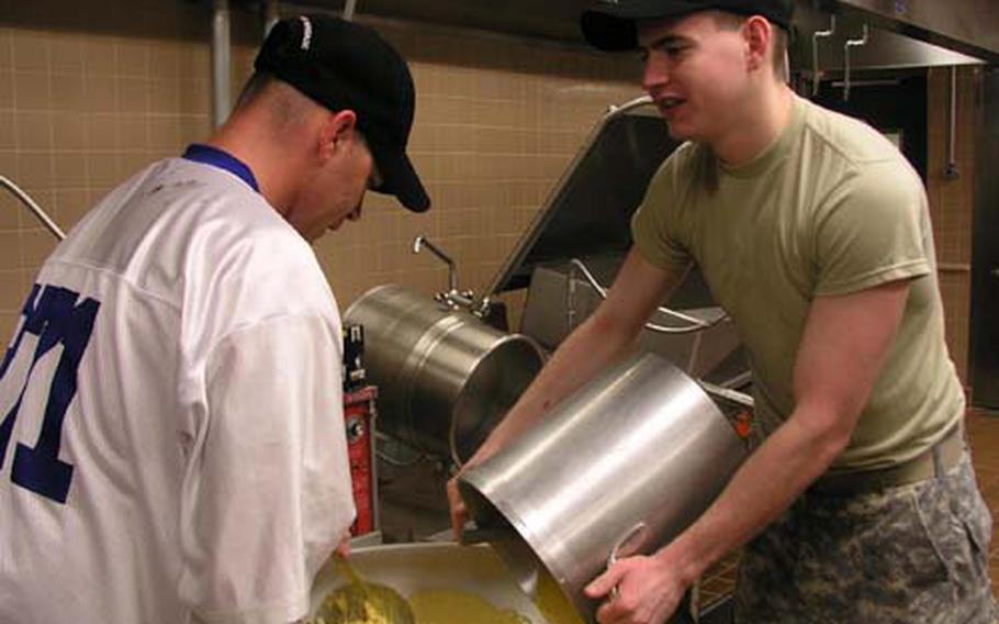 Spc. David Clark, left, 28, of Hardy, Ark., and Pvt. Paul Emig, 21, of New Castle, Pa., prepare a macaroni dish on Thursday just a few hours before the midday meal at the Talon Cafe dining facility at Camp Humphreys, South Korea.