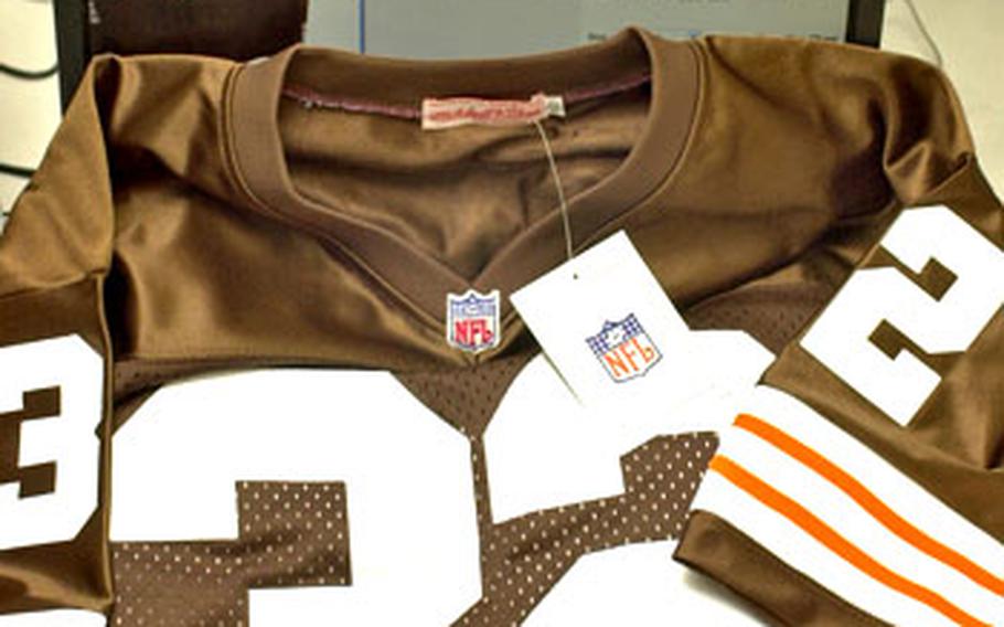 A jersey purchased for $15 at a store outside Camp Casey in South Korea is displayed in front of the NFLshop.com Web page advertising the jersey from the same manufacturer for $284.99. However, given differences between the jersey and the one pictured on the Web page — including the NFL logo on the neckline and the length of the sleeves — the one purchased appears to be a knockoff. Mitchell & Ness patches have apparently been affixed to a Reebok-style jersey.