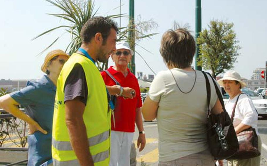 Antonio Solla directs tourists to the Beverello pier in downtown Naples. Solla and 80 other former convicts are part of an experimental program funded by the Campania regional government that hires former petty criminals to help tourists keep safe while visiting the city.