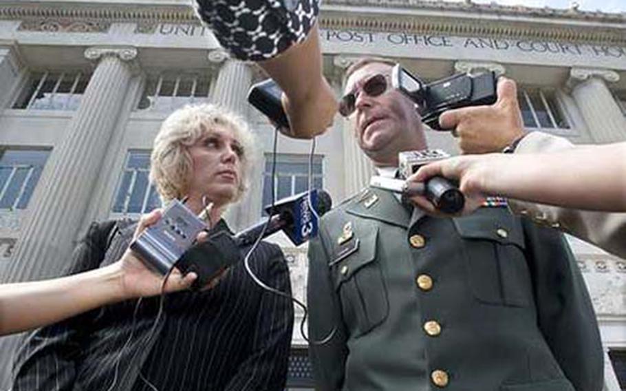 Maj. Stefan Cook speaks to the media with his attorney, Orly Taitz, after his case was dismissed on July 16 outside the federal courthouse in Columbus, Ga.