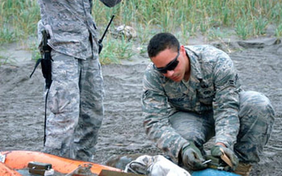 Staff Sgt. Michael Overton, left, and Airman 1st Class William Holliday prepare 500-pound inert training bombs for destruction Friday at the Draughon Range.