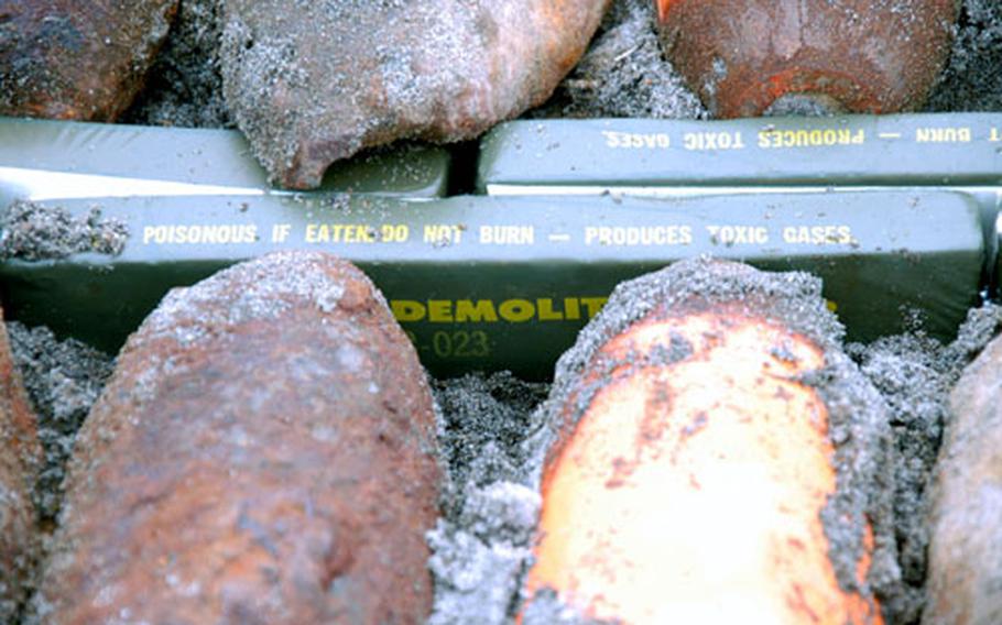Bricks of C-4 explosives sit between old dummy training bombs during an annual clean-up on Draughon Range.