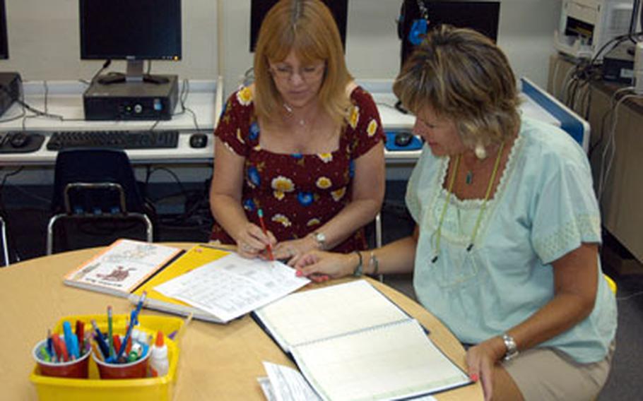Grant Okubo/Stars and Stripes First-grade teacher Melissa Alexander, left, and gifted education teacher Kippy Sinclair work on plans Wednesday for the upcoming school year at Yokota West Elementary School in Japan. Diana Ohman, the director of Department of Defense Dependents Schools in the Pacific region, said teachers need to be vigilant to spot students who may need extra attention due to a deploying parent.