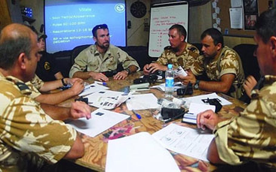 Petty Officer 1st Class Ben “Doc” Taylor, center, a hospital corpsman from Naval Air Station Sigonella, Sicily, talks Romanian airmen through the process of using a tourniquet. Taylor is serving at FOB Lagman as the medic assigned to Platoon 821 of Explosive Ordnance Disposal Mobile Unit 8.