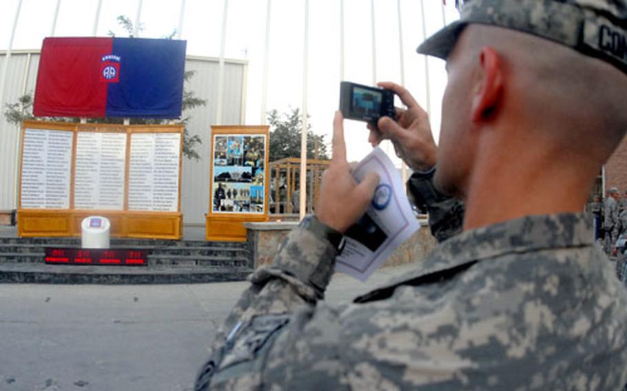 Army Maj. Justin Considine, 33, takes a picture of a memorial wall at Bagram Air Base, Afghanistan, listing military personnel killed when hijacked American Airlines Flight 77 crashed into the Pentagon on Sept. 11, 2001.